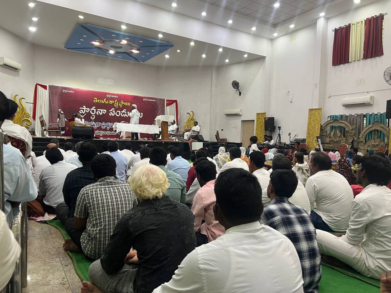 Believers gathered before the stage at a recent ministry meeting