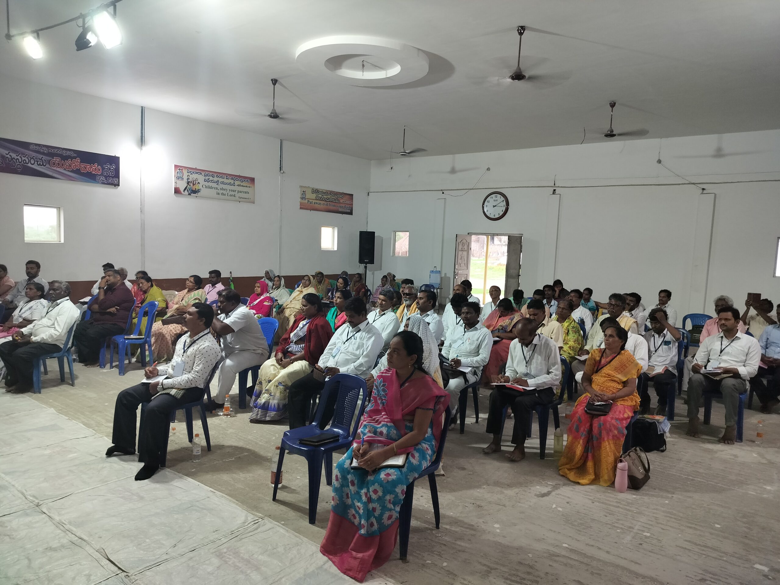 Believers seated and taking notes during a ministry gathering in India